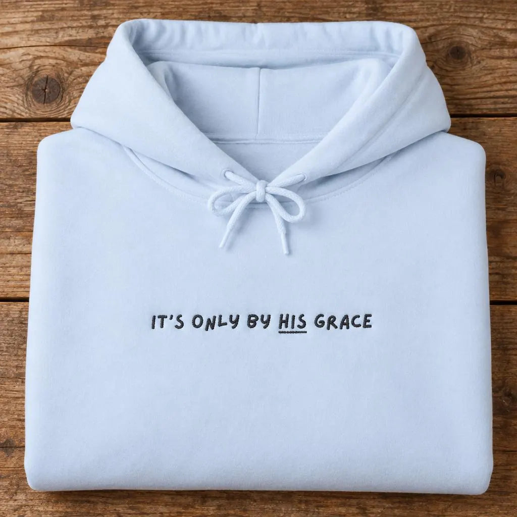 Folded light blue hoodie with black It's only by His grace chest lettering